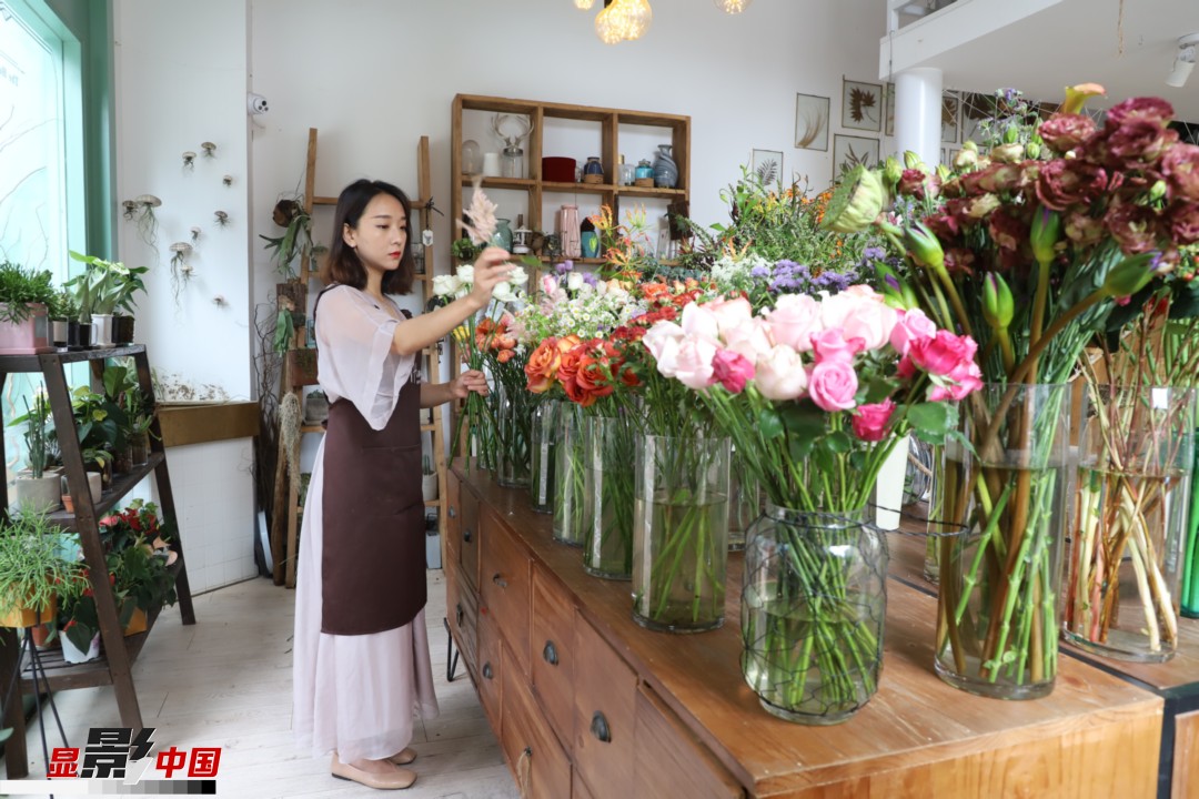 王黎媛是一名河南姑娘，在昆明念完大學(xué)后，就再也舍不下春城的藍(lán)天陽(yáng)光、青山碧水，更舍不下這里的四時(shí)繁花，于是就干脆留了下來，成了一名媒體人。2017年的時(shí)候又毅然辭去工作，創(chuàng)業(yè)開起了花店，成了都市里的一名“花房姑娘”。圖為王黎媛在自己的花店中整理鮮花。新華網(wǎng) 周亞平/攝 念新洪/文
